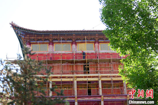 圖為5月上旬，甘肅山丹縣大佛寺內(nèi)，工作人員對(duì)古建筑大雄寶殿進(jìn)行修繕。 中新社記者 高展 攝