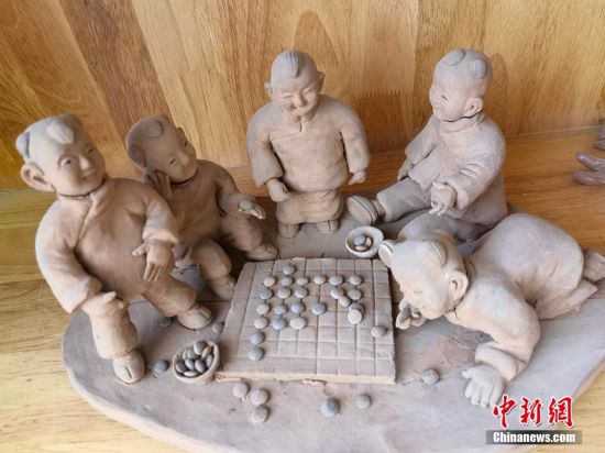 圖為泥塑作品展現(xiàn)下棋場(chǎng)景。 劉玉桃 攝