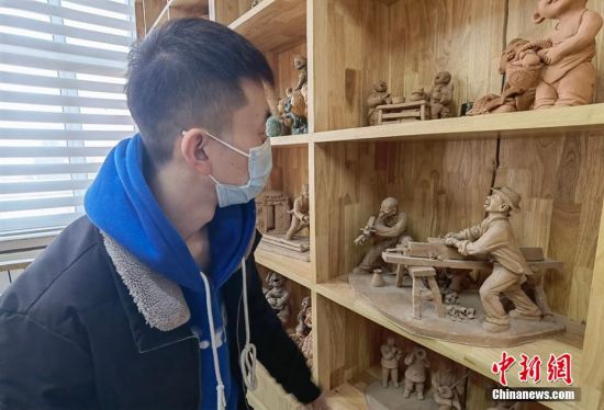圖為學(xué)生欣賞泥塑作品。 劉玉桃 攝