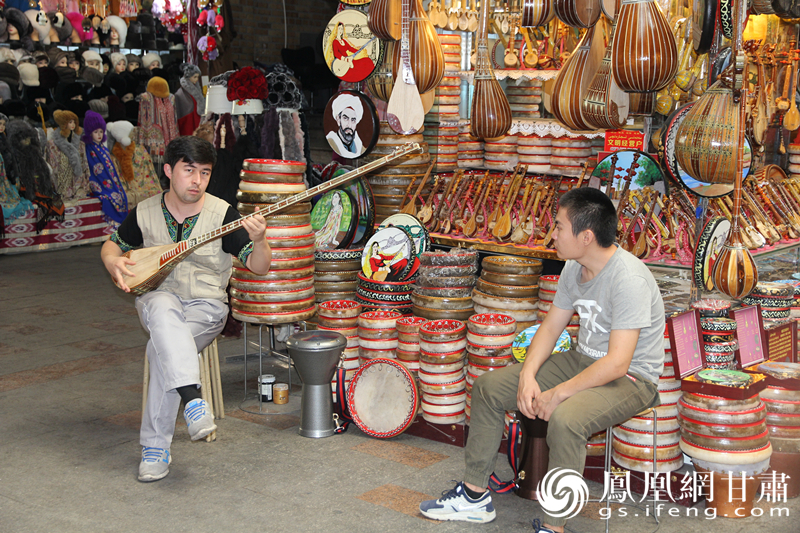 烏魯木齊二道橋巴扎內，店主正在向客人展示樂器。楊文遠 攝
