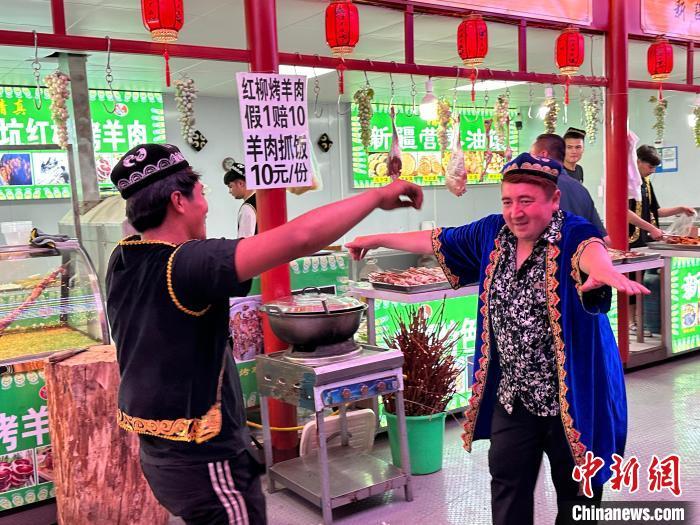 圖為餐飲經(jīng)營者在“西涼不夜城”跳起舞蹈引客?！〈魑牟?攝</p><p>