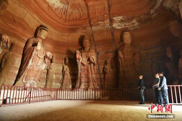 7月15日，游人參觀甘肅省平?jīng)鍪袥艽h百里石窟長(zhǎng)廊中的南石窟寺1號(hào)窟。百里石窟長(zhǎng)廊位于涇川縣境內(nèi)，由512個(gè)石窟、5眼窟中石井組成，現(xiàn)存王母宮石窟、鳳凰山石窟、南石窟寺、丈八寺石窟、羅漢洞石窟、太山寺石窟等規(guī)模較大的石窟群，還有數(shù)量眾多的小石窟群。南石窟寺開(kāi)鑿于北魏永平三年，其中1號(hào)窟屬于大型七佛窟，七佛高達(dá)6米。中新社記者 李亞龍 攝
