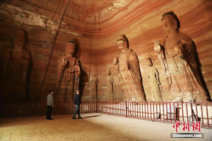 7月15日，游人參觀甘肅省平?jīng)鍪袥艽h百里石窟長(zhǎng)廊中的南石窟寺1號(hào)窟。百里石窟長(zhǎng)廊位于涇川縣境內(nèi)，由512個(gè)石窟、5眼窟中石井組成，現(xiàn)存王母宮石窟、鳳凰山石窟、南石窟寺、丈八寺石窟、羅漢洞石窟、太山寺石窟等規(guī)模較大的石窟群，還有數(shù)量眾多的小石窟群。南石窟寺開(kāi)鑿于北魏永平三年，其中1號(hào)窟屬于大型七佛窟，七佛高達(dá)6米。中新社記者 李亞龍 攝